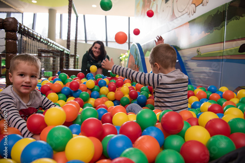 Young mom with her kids in a children's playroom photo