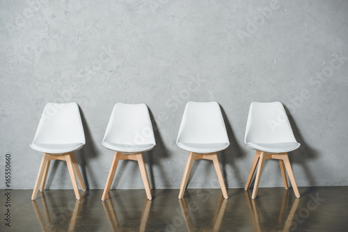 Fotografie white empty chairs for job interview standing in line in hall