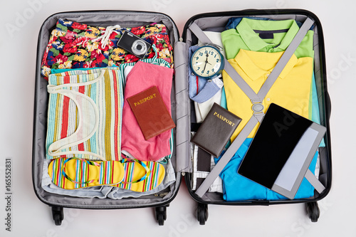 Essential things for going abroad. Suitcase with beach clothes and accessories.