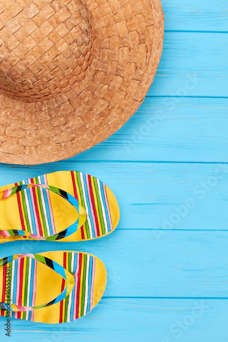 Straw hat, slippers close up. Beach accessories in left border.
