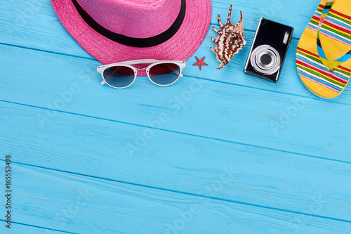Colorful summer women accessories. Women beach things, wooden colored background.