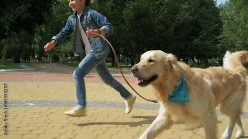 Overjoyed little boy running with his dog