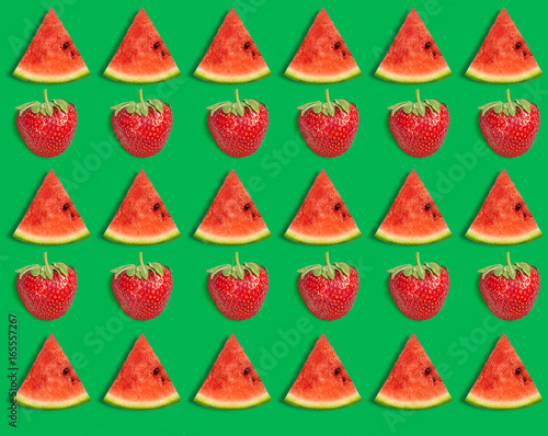 Watermelon pattern. Sliced watermelon and strawberry on green background. Summer concept. Flat lay, top view photo