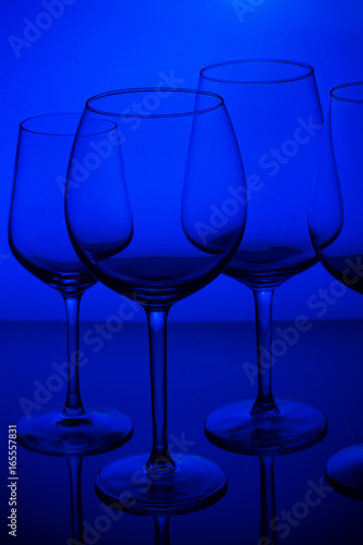 Set of empty wine glasses on blue background