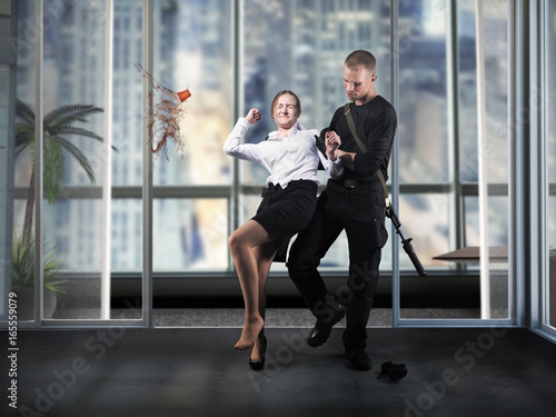 Fotografi The man with the guns seized the girl, an employee of the office