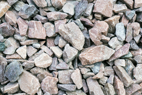Small rock crushed stone road-metal. Pile of white, grey and yellow rocks. Road-metal background
