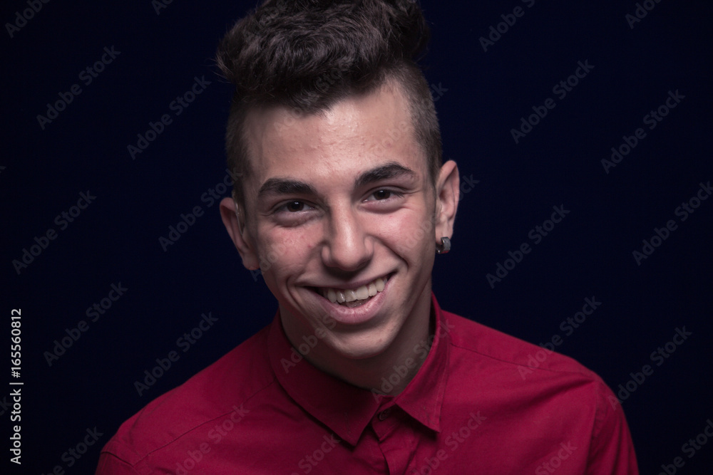 ordinary portrait, one teenager boy, red shirt, Caucasian, dark background, looking to camera, smiling