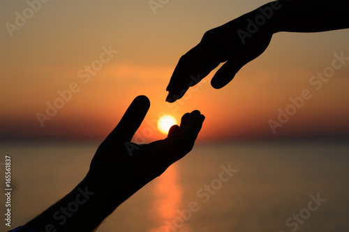 A man holds the sun in his hands and gives it to his beloved girl. Love and romance.