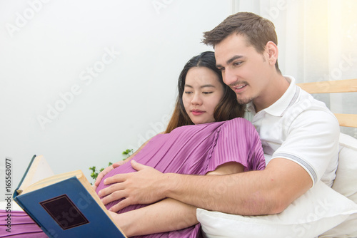 pregnant woman and her handsome husband reading a book