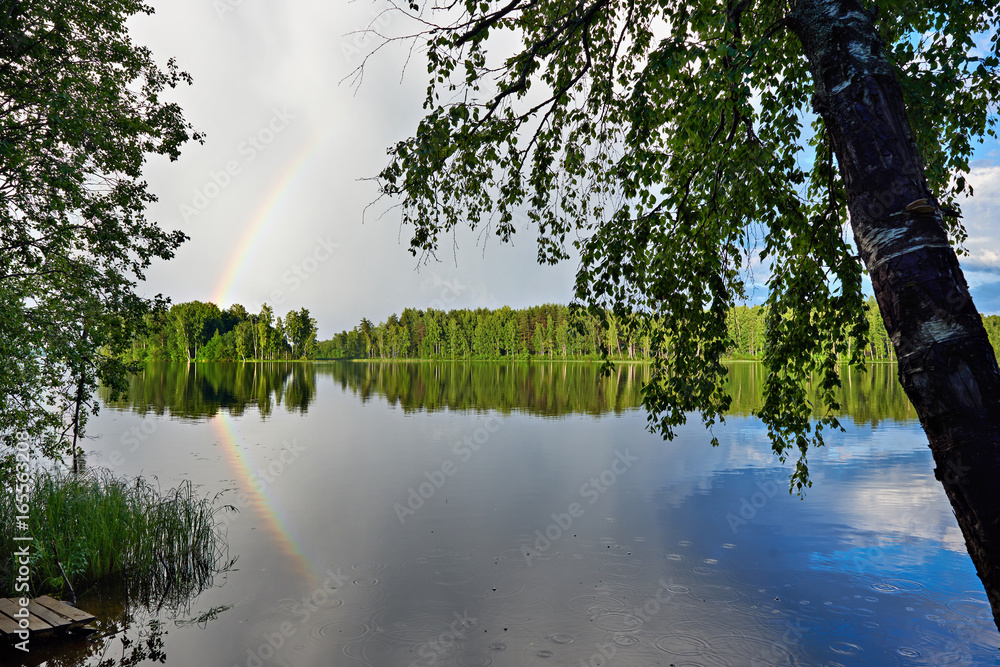 Landscape with rainbow on shore of lake