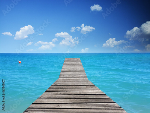 Tropical beach - blue water with wooden floor