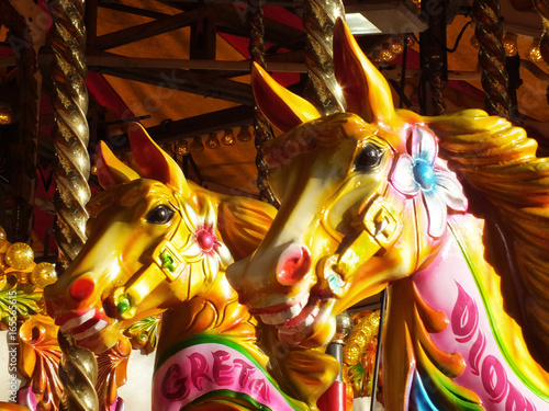 brightly coloured carousel horses on a vintage fairground ride
