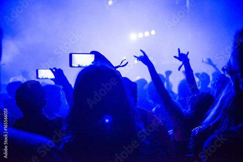 Raised arms holding smart phones to recording a live concert