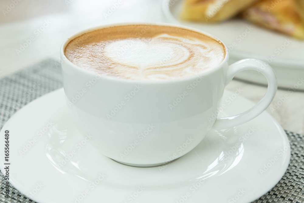 Heart shape of latte art coffee in white cup on desk Heart shape of latte art coffee in white cup on desk