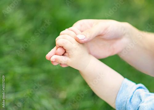 Mother holding hand of a small child © Tetiana