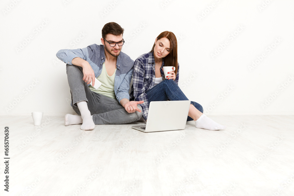 Casual couple working with laptop, studio shot