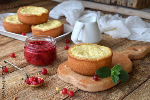 Mini cowberry cheesecake in muffin forms. Served in cutting board with jam and berries. Copy space