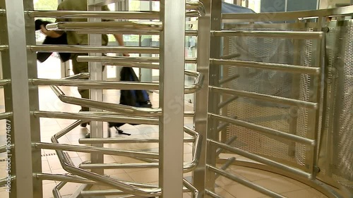 Turnstile. Revolving exit, door. People pass a turnstile at the bus, railway, subway station. Business building. Security metal detector. 3