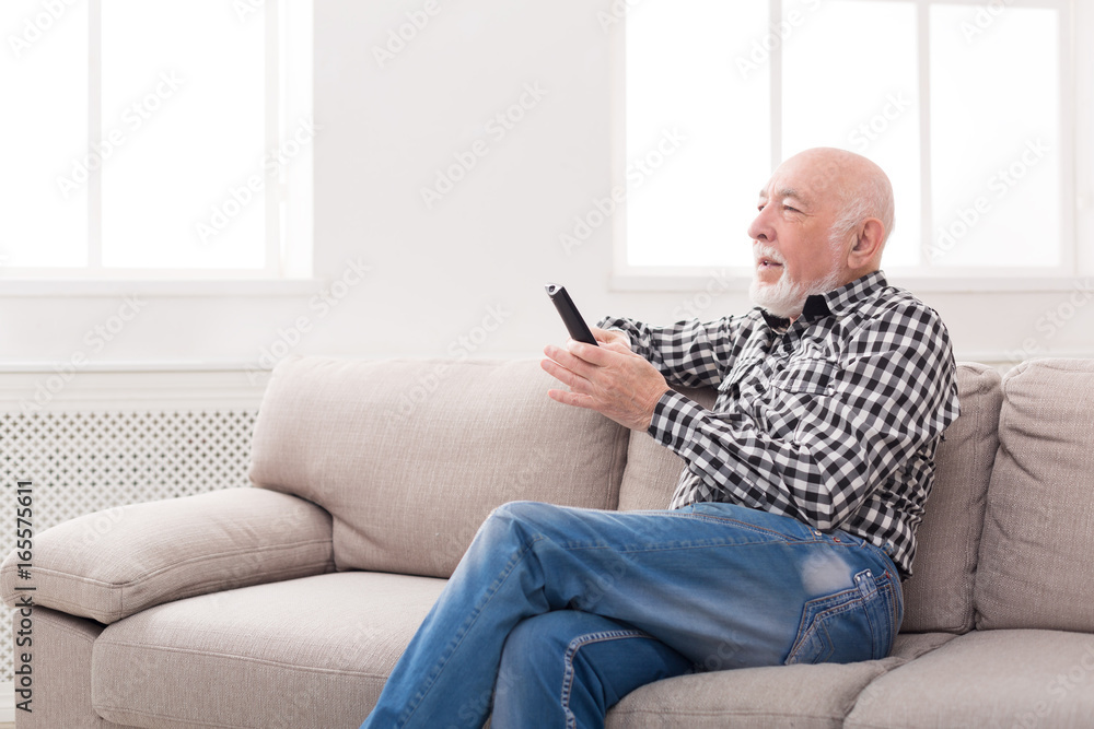Emotional senior man watching tv copy space