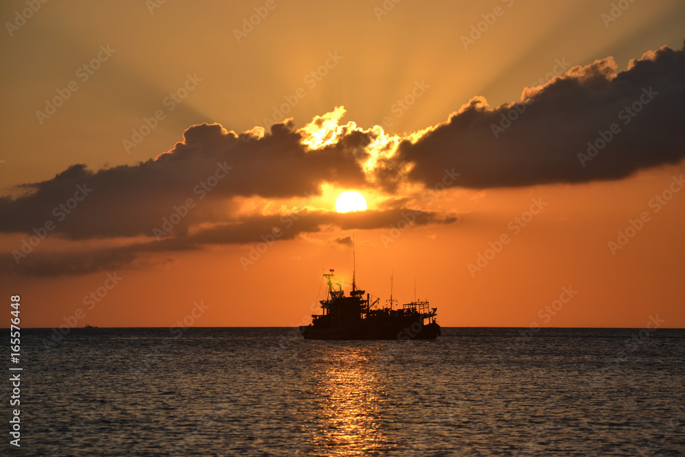 Silheoutte of a ship during sunset with ray of light.