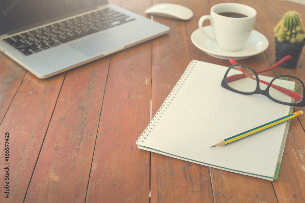 Wooden table with notepad, computer and coffee cup. View from above with copy space. Wooden table with notepad, computer and coffee cup. View from above with copy space.