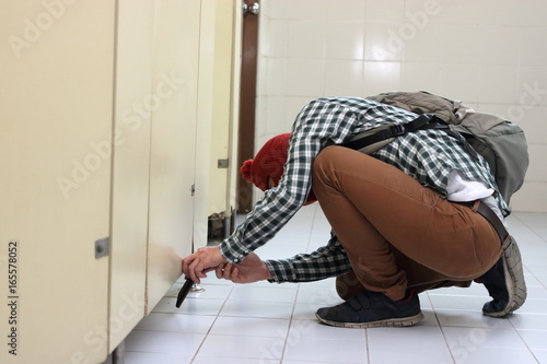 Fotografie Masked thief with a balaclava sneaking and taking a photo with mobile smart phon