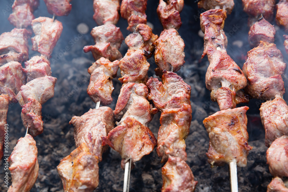 Marinated shashlik preparing on a barbecue grill over charcoal