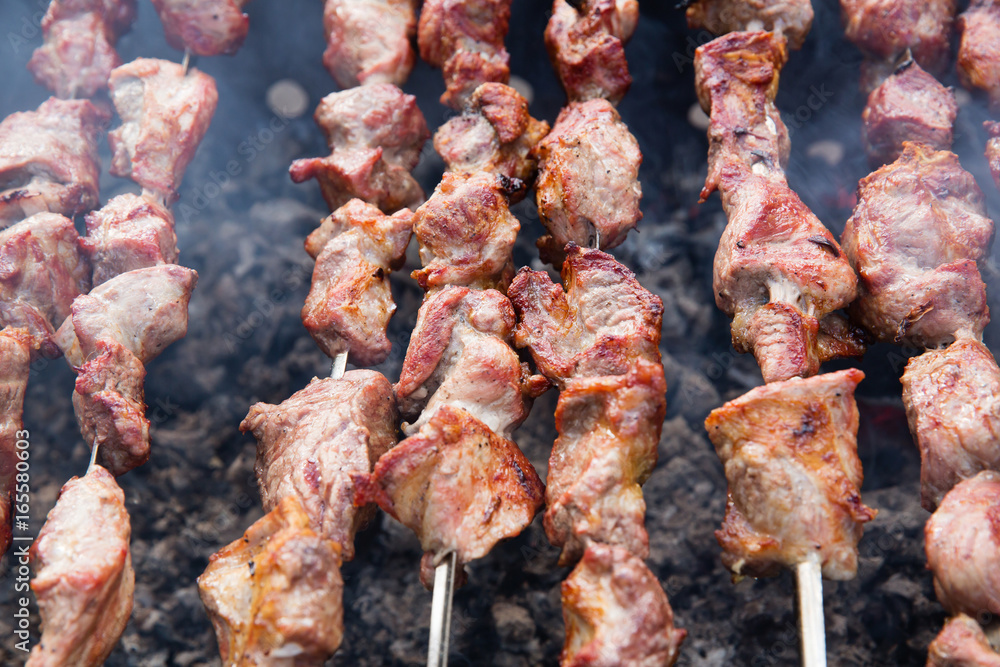 Marinated shashlik preparing on a barbecue grill over charcoal Marinated shashlik preparing on a barbecue grill over charcoal