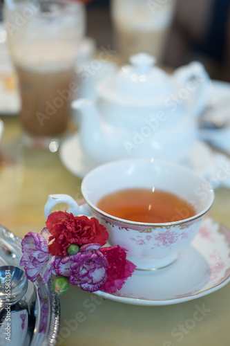 Cup of tea with flower decor on saucer