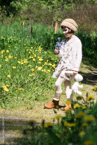 Pretty little girl on the meadow in spring day