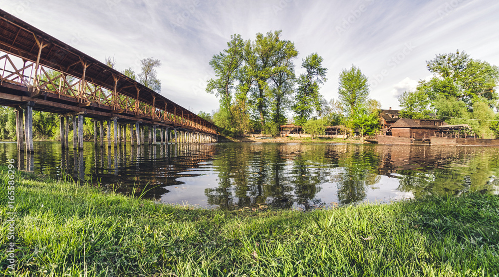 Fototapeta premium Wooden pedestrian bridge over river in Kolarovo, Slovakia