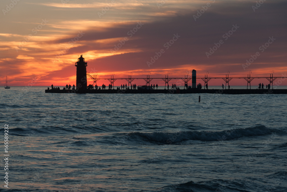 Dramatic photo of lighthouse and pier at sunset.