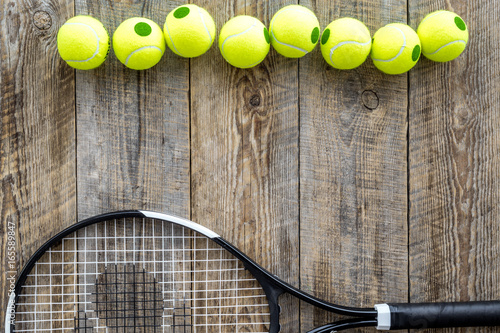 Sport gear. Tennis balls and racket on wooden background top view copyspace © 9dreamstudio