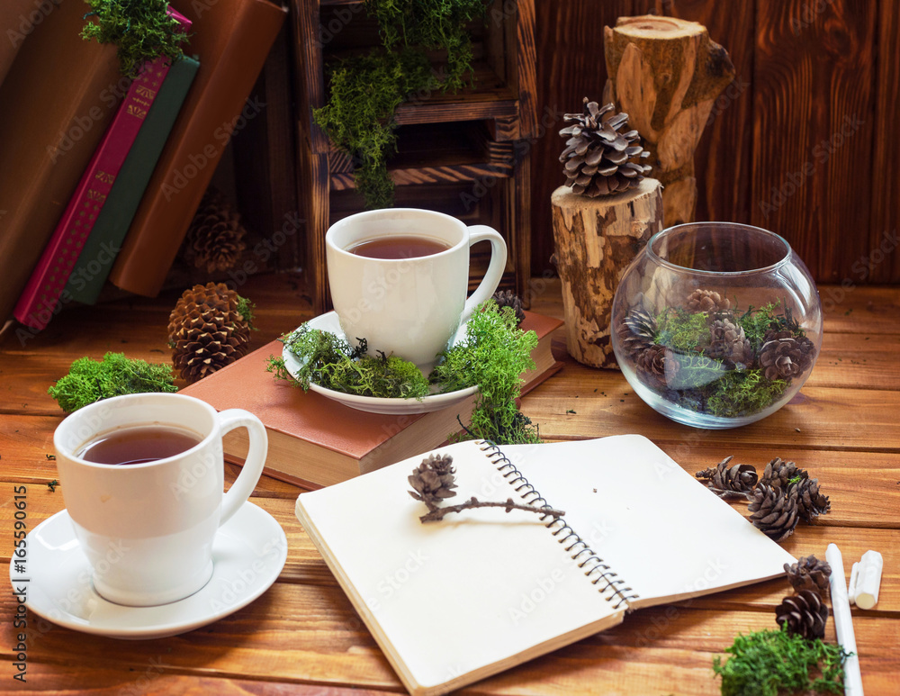 Cups with tea or coffee on a wooden background. Morning breakfast with cones and a book Cups with tea or coffee on a wooden background. Morning breakfast with cones and a book