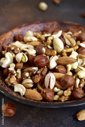 Assortment of nuts in a clay bowl.