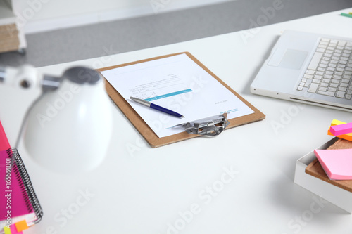 Closeup of white desktop with notepads, pen and other items. Selective focus.