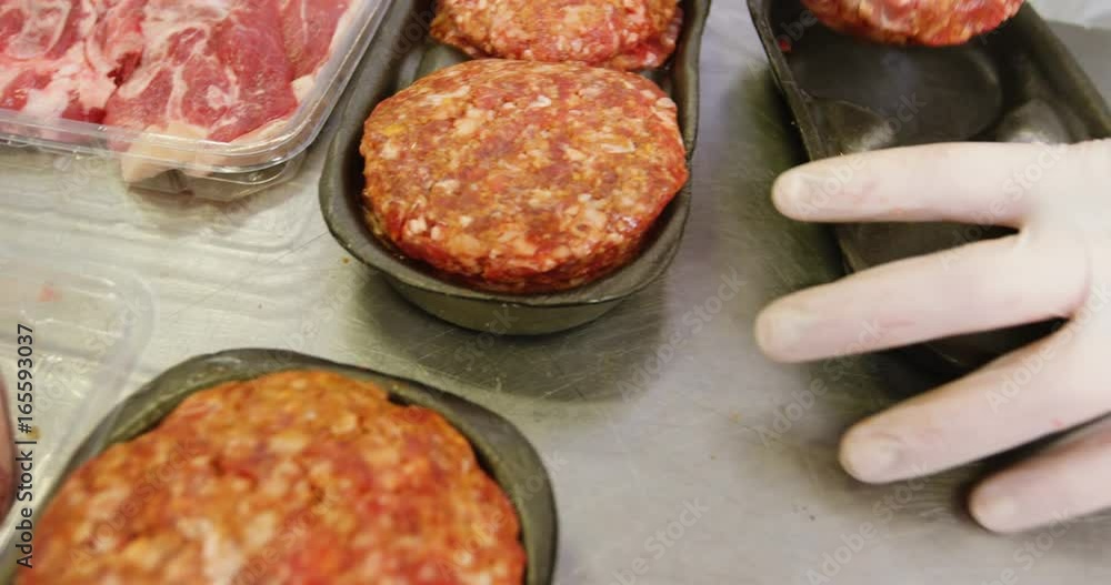 Hand of butcher packing baked meat in container Hand of butcher packing baked meat in container