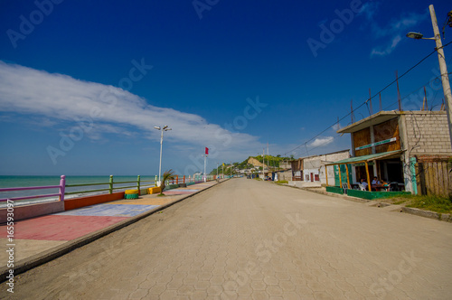 Stoned pavement road in the coast, surrounded with abundat vegetation in a sunny day in the Ecuadorian coasts photo