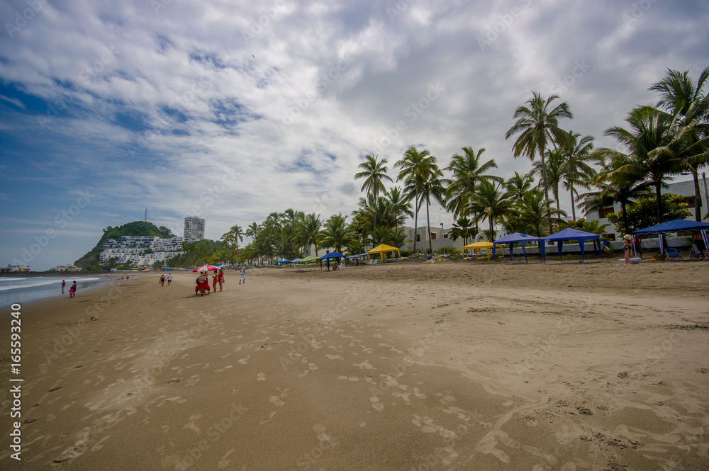 Beautiful view of the beach with sand, and buildings behind in a beautiful day in with sunny weather in a blue sky in Same, Ecuador
