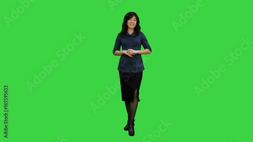 Young asian women standing and talking to a camera on a Green Screen, Chroma Key