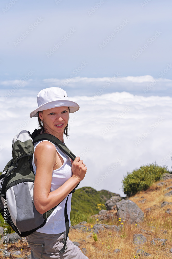 Young woman in mountains above the clouds.