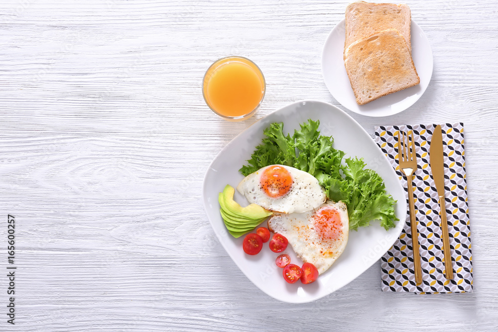 Delicious breakfast with fried eggs on white wooden table Delicious breakfast with fried eggs on white wooden table
