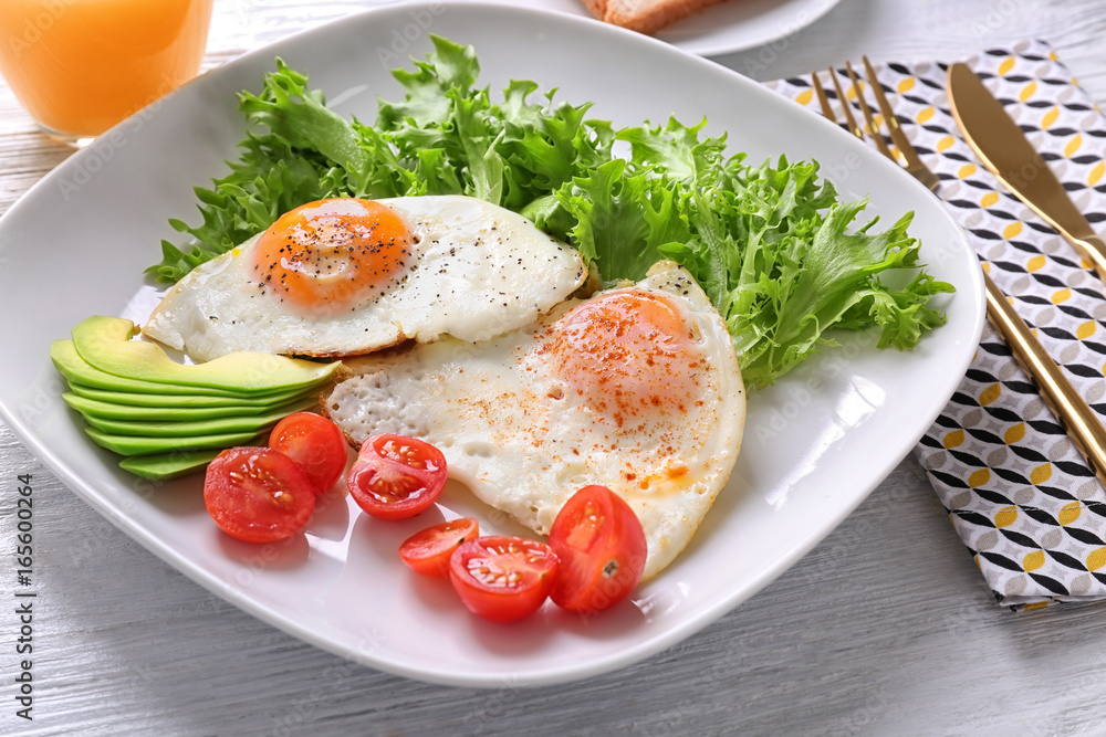 Delicious breakfast with fried eggs on white wooden table Delicious breakfast with fried eggs on white wooden table
