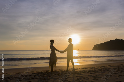 A couple holding hands during an amazing sunset. Loving couple in the pond at sunset hug