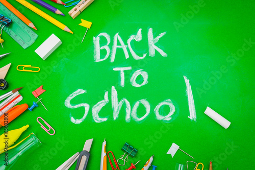 School supplies on Green chalkboard " Back to school background " .