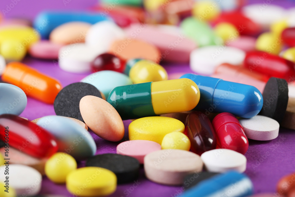 Different colorful pills on pink background Different colorful pills on pink background