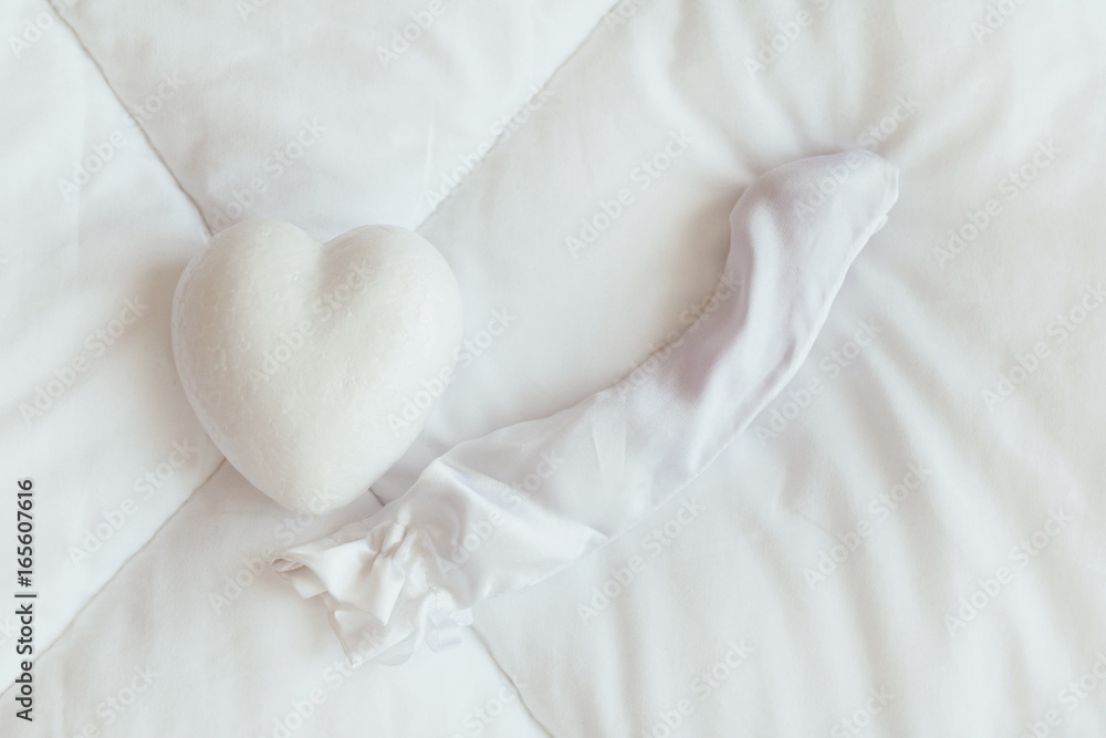 Heart and dildo sex toy on the white blanket Heart and dildo sex toy on the white blanket
