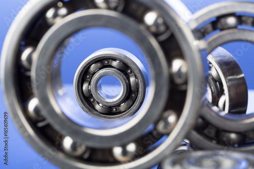 Group of various ball bearings close up on nice blue background.