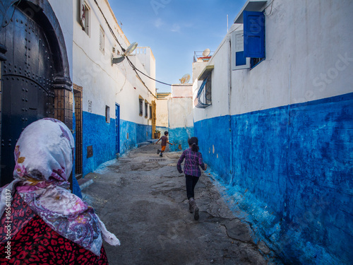 Fototapeta Naklejka Na Ścianę i Meble -  Kids running down colourful alley in Morocco