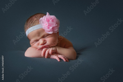 Newborn girl with hairband sleeps